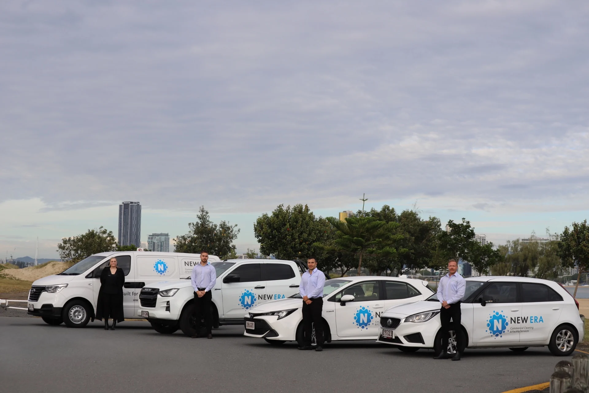 The New Era team standing with a line-up of branded New Era service vehicles on the Gold Coast waterfront