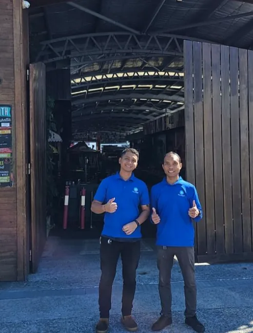Two New Era cleaners in branded polos at the entrance of a hospitality venue at the start of a shift