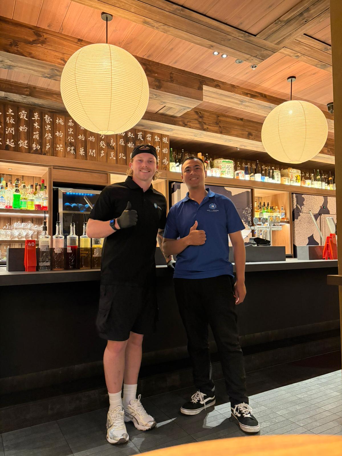 Two New Era hospitality team members at a venue bar in Australia